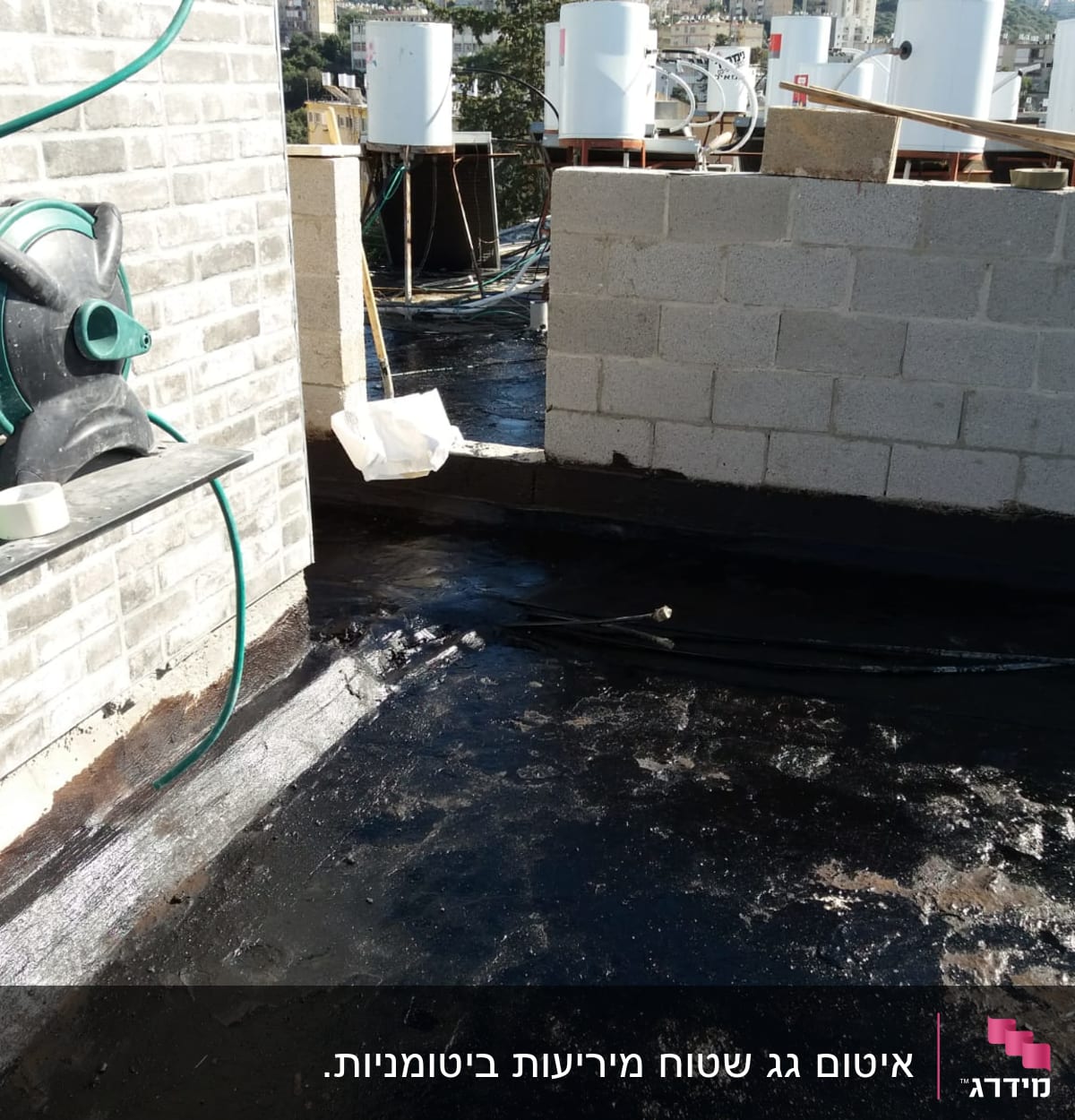 גג אטום בזפת עם צינורות ומיכלים